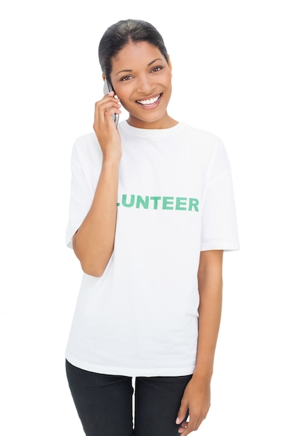 Foto gelukkig model die vrijwilligert-shirt dragen die een telefoongesprek hebben