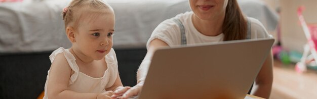 Foto gelukkig moeder en kind dochter vrije tijd doorbrengen en tekenfilms kijken op laptop thuis