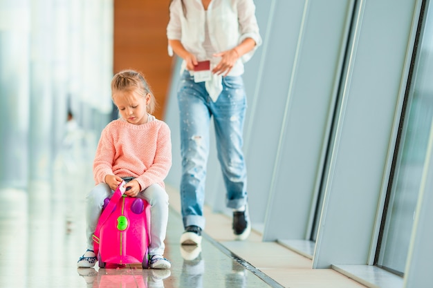 Gelukkig moeder en meisje met instapkaart op de luchthaven