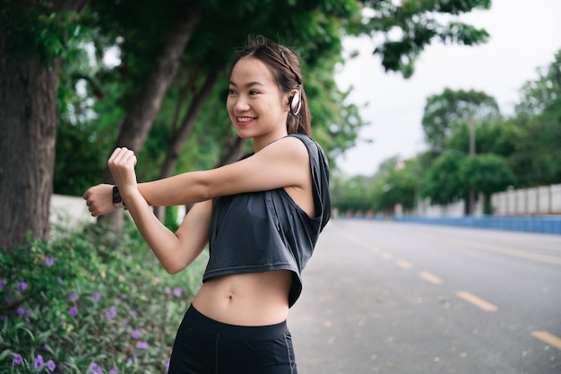 Gelukkig mooi meisje arm uitrekken voordat joggen