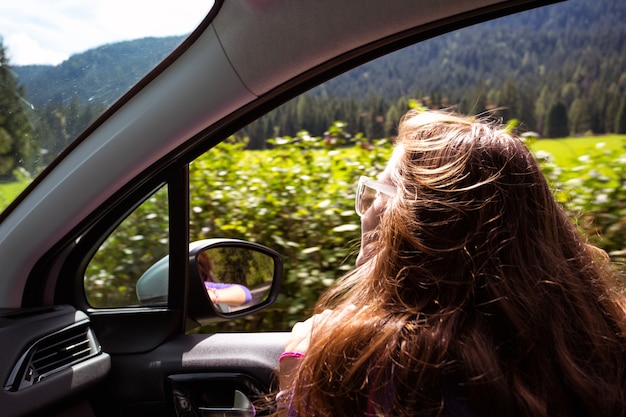 Gelukkig mooi meisje reizen in een auto over de bergen Dolomieten, Italië. Europa