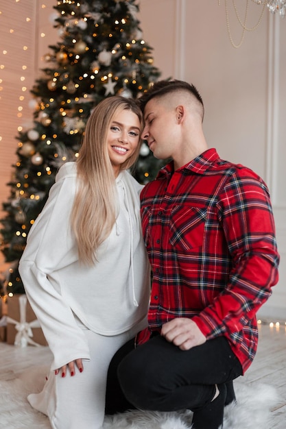Gelukkig mooi paar verliefd in de buurt van de kerstboom thuis