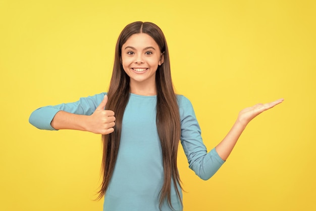 Gelukkig mooi uiterlijk van jong meisje gezicht portret van kind op gele achtergrond