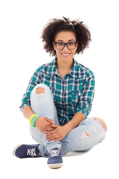 Gelukkig mooie Afro-Amerikaanse tienermeisje zitten geïsoleerd op een witte achtergrond