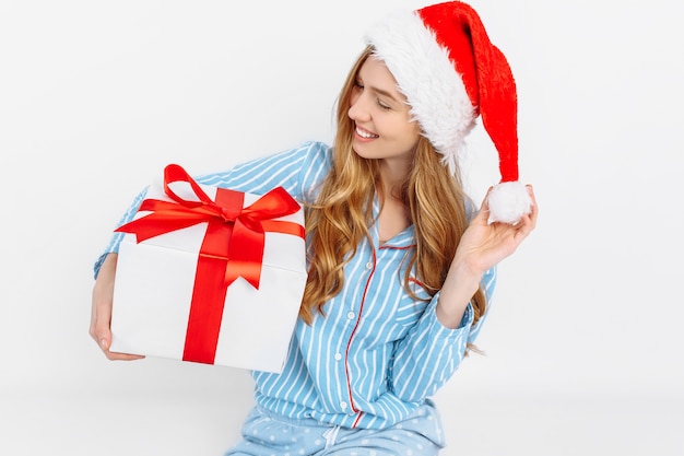 Foto gelukkig mooie jonge vrouw in pyjama's van kerstmis