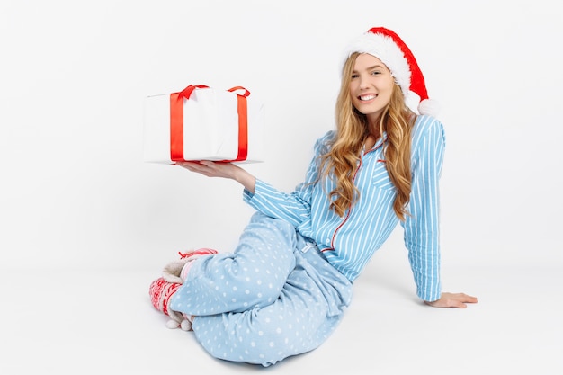 Foto gelukkig mooie jonge vrouw in pyjama's van kerstmis