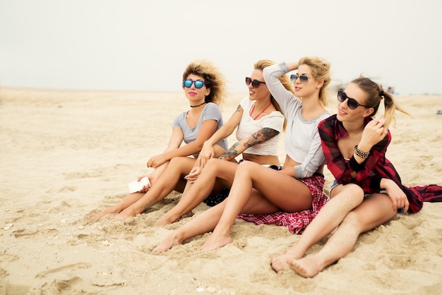 Gelukkig mooie meisjes zitten op het strand.