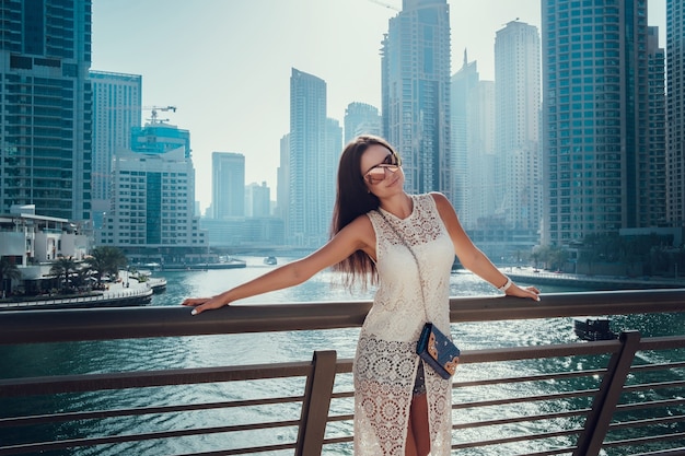Gelukkig mooie onherkenbaar toeristische vrouw in modieuze witte zomerjurk genieten in Dubai