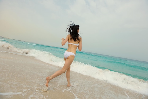 Gelukkig mooie vrouw genieten van zomervakantie op het strand