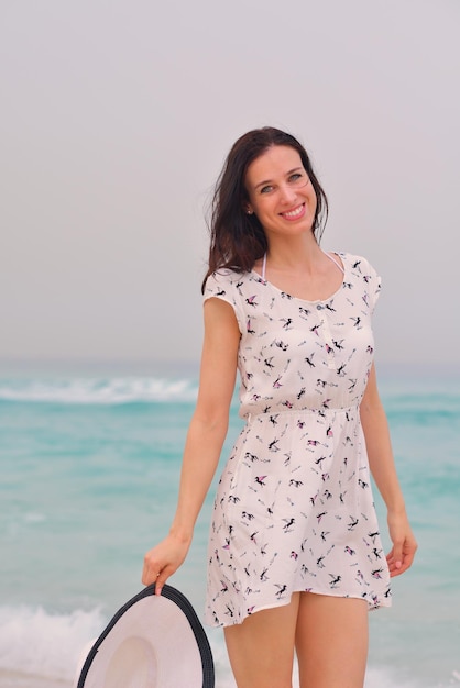 Gelukkig mooie vrouw genieten van zomervakantie op het strand