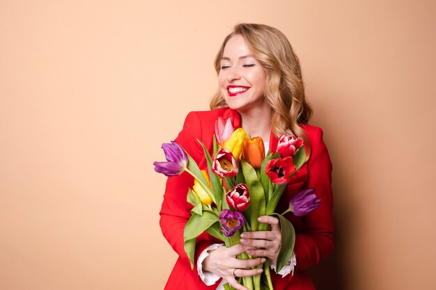 Gelukkig mooie vrouw poseren met bloemen en lachen