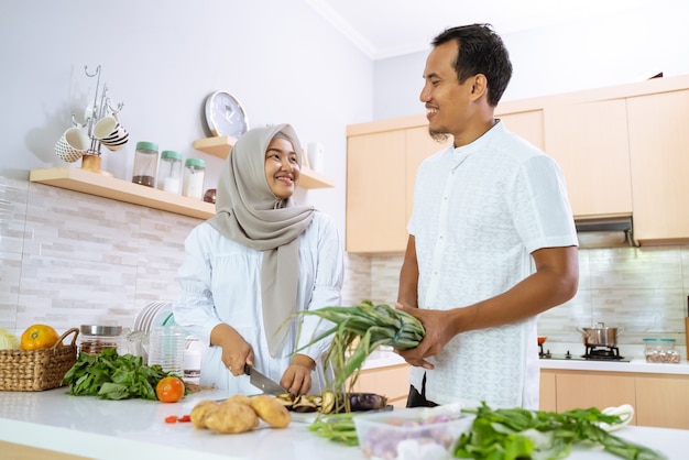 Gelukkig moslim paar samen koken in de keuken. man en vrouw bereiden zich voor op het diner