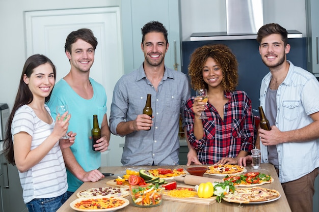 Gelukkig multi-etnische genieten van alcohol en pizza aan tafel