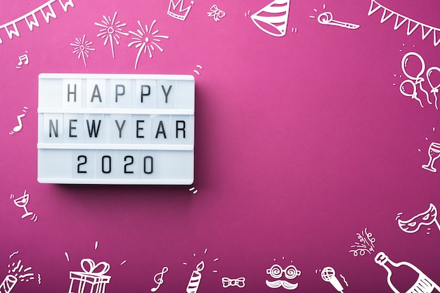 Gelukkig nieuw jaar 2020 lichtbak met doodle item decoratie vakantie item bovenaanzicht op paarse tafel