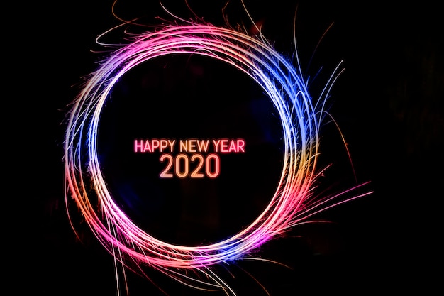 Gelukkig Nieuwjaar 2020: geschreven in fonkelende cirkel op zwarte achtergrond