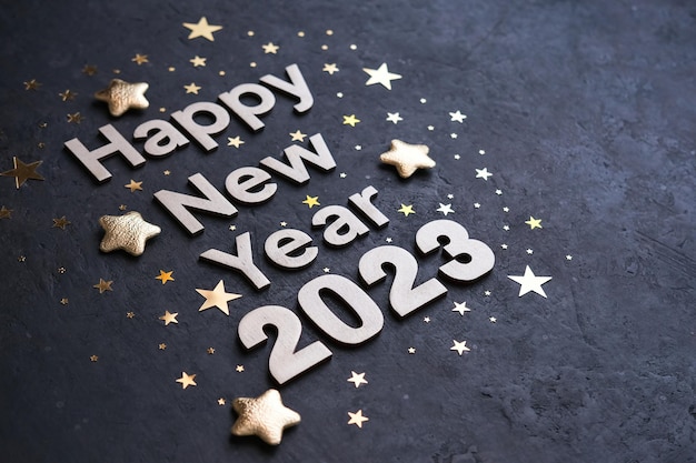 Gelukkig nieuwjaar 2023 Gouden getallen 2023 met gouden sterren op een donkere achtergrond Nieuwjaarswenskaart