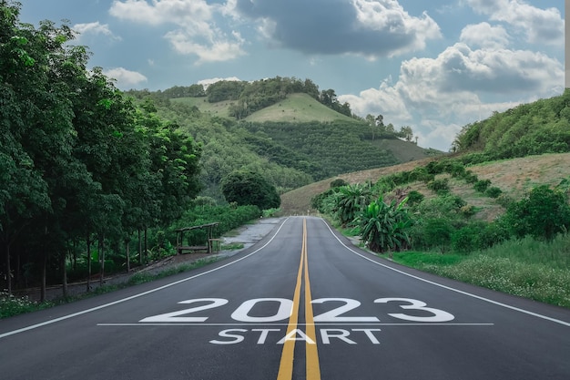 Gelukkig nieuwjaar 20232023 symboliseert de start van het nieuwe jaar de brief start nieuw jaar 2023 op de weg in de natuurroute rijweg heeft een boommilieu-ecologie of groenbehangconcept