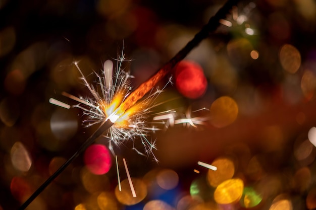 Gelukkig Nieuwjaar Glinsterende brandende sterretje tegen wazig confetti bokeh lichte achtergrond