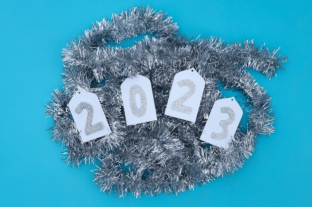 Gelukkig nieuwjaar met nummers 2023 en zilveren glitter feestelijke ornamenten op blauwe achtergrond. plat liggen,
