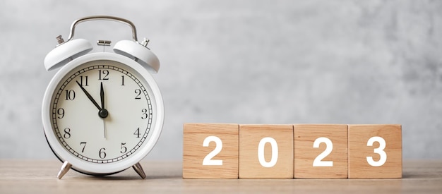 Gelukkig nieuwjaar met vintage wekker en 2023 blok kerstmis nieuwe start resolutie aftellen doelen plan actie en motivatie concept