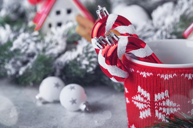 Gelukkig Nieuwjaar of Merry Christmas Gestreepte snoepstokjes in rode kop op achtergronden gezellige huizen gewikkeld kerstboomtakken in sneeuw en bokeh met plaats om tekst te kopiëren Wenskaart voor Kerstmis