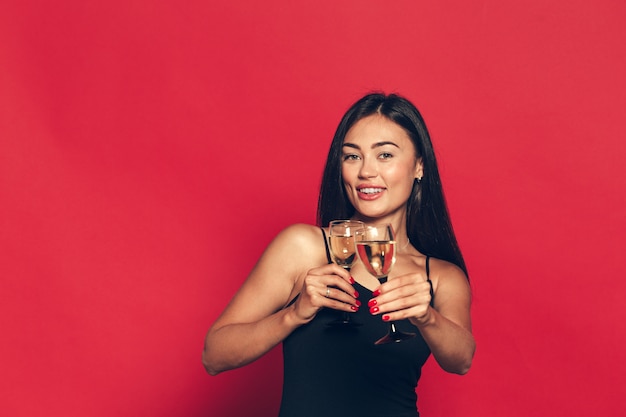 Gelukkig nieuwjaar voor jou. Een jonge en mooie vrouw dansen met glas champagne