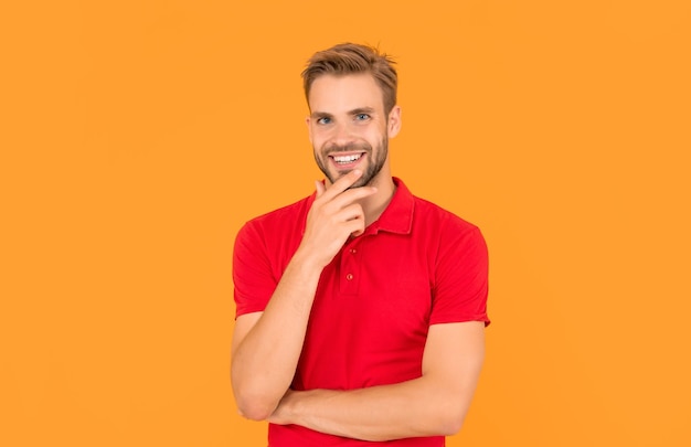 Gelukkig ongeschoren jonge man in rood shirt op gele achtergrond casual
