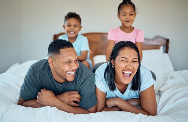 Gelukkig ontspannen en glimlachen met familie in de slaapkamer voor een grappige band en 's ochtends wakker worden Weekend opgewonden en genegenheid met ouders en kinderen die thuis spelen voor quality time zorg en rust