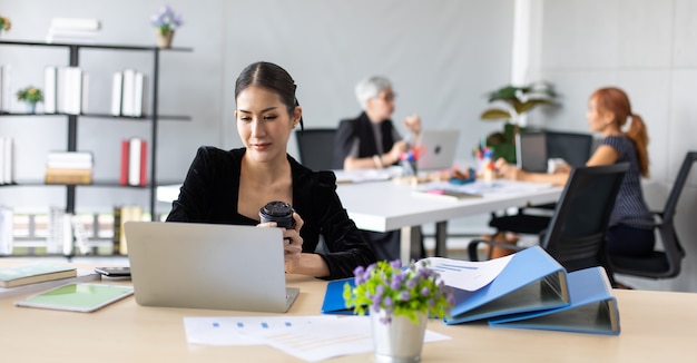 Gelukkig opgewonden succesvolle Mooie zakenvrouw koffie drinken werken op kantoor met laptop, succes gelukkig pose. Thuiswerken en social distancing concept