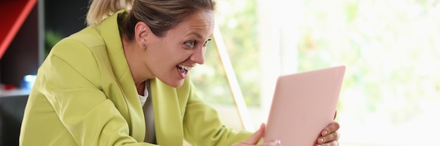 Foto gelukkig opgewonden succesvolle zakenvrouw die laptop vasthoudt en viert in het kantoor, winnaar goed