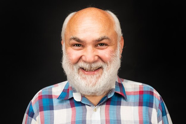 Gelukkig oude volwassen man glimlachend portret van een kale oude volwassen senior man met grijze baard op zwarte stud