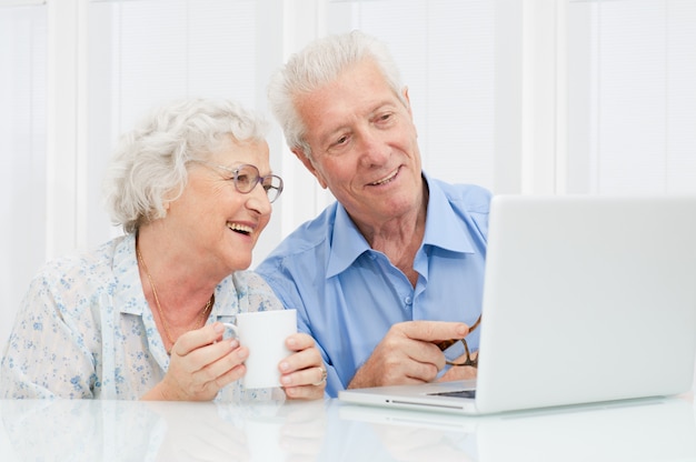 Gelukkig ouder paar geniet samen op laptopcomputer