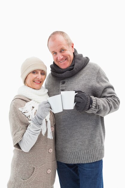 Gelukkig ouder paar in de winterkleren die mokken houden