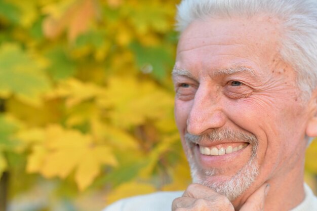 Gelukkig oudere man poseren in herfst park