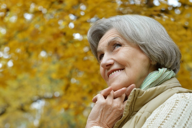 Gelukkig oudere vrouw genieten in herfst park