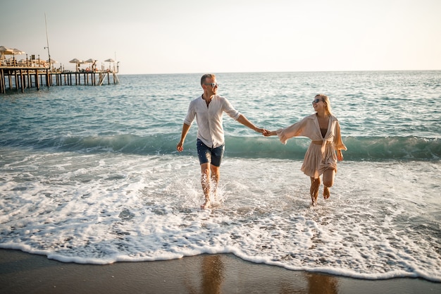 Gelukkig paar aan zee. Liefhebbers van huwelijksreizen. Man en vrouw op het eiland. Mooie paar plezier aan de kust. Gelukkig paar op vakantie. Man en vrouw aan zee.