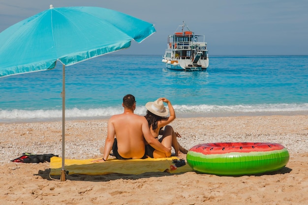 Gelukkig paar dat bij het gelukkige strand van Griekenland rust