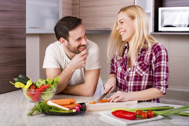 Gelukkig paar dat een verse salade met groenten op het aanrecht maakt