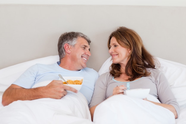 Gelukkig paar dat graangewassen in bed eet