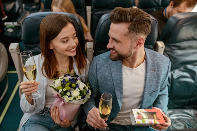 Gelukkig paar dat jubileum viert en champagne drinkt in het vliegtuig