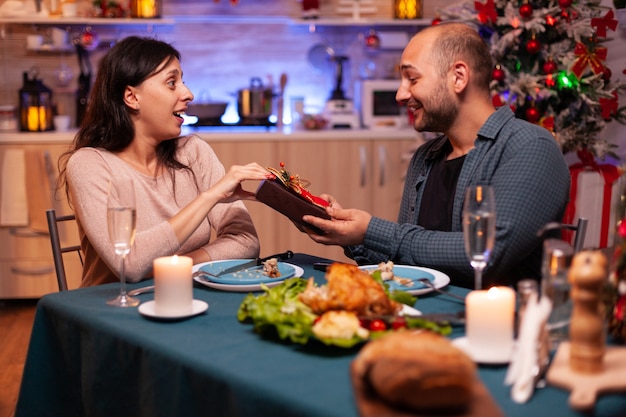 Gelukkig paar dat kerstvakantie doorbrengt, verrassend met kerstcadeau