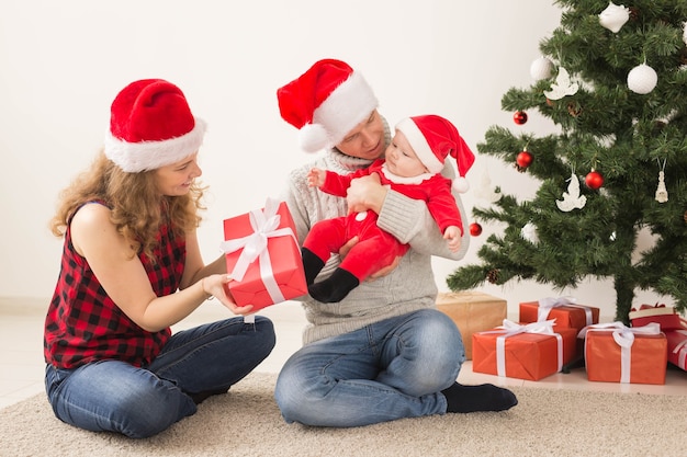 Gelukkig paar dat met baby Kerstmis samen thuis viert.