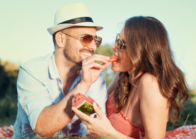 Gelukkig paar dat op een picknick watermeloen eet