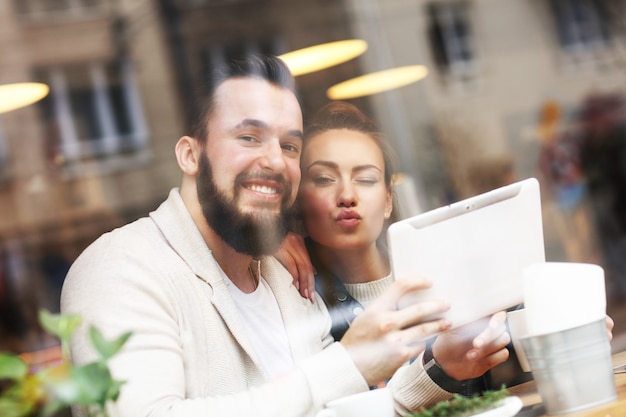 gelukkig paar dat tablet in restaurant gebruikt