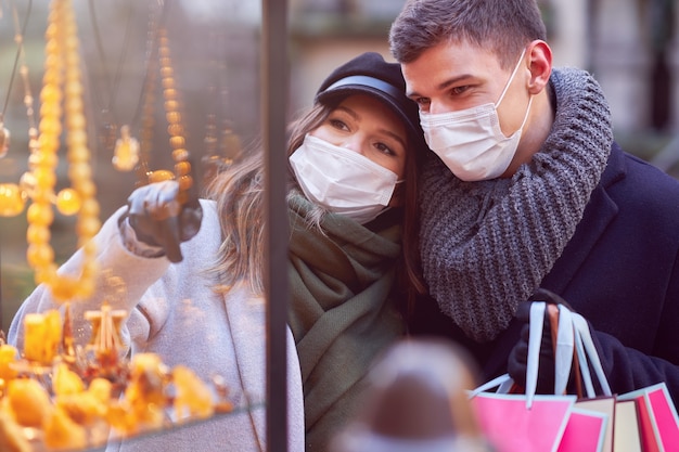 Gelukkig paar dat Valentijnsdag in maskers viert tijdens de covid-19-pandemie in de stad