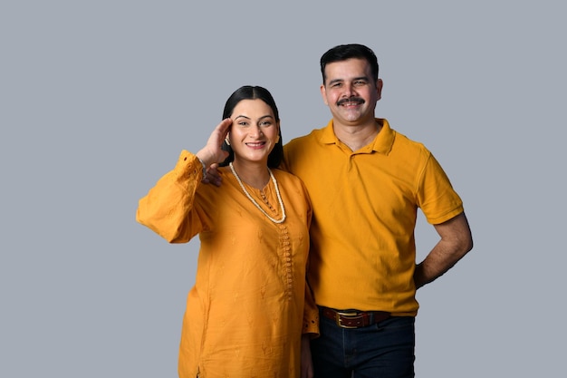 gelukkig paar dat vooraan kijkt tegen grijze muur Indisch Pakistaans model