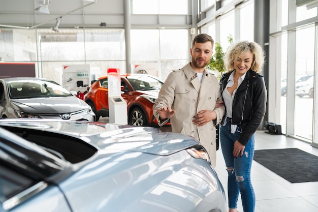 Gelukkig paar die auto's in dealer kiezen