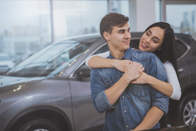 Gelukkig paar die nieuwe auto kopen bij handel drijvensalon