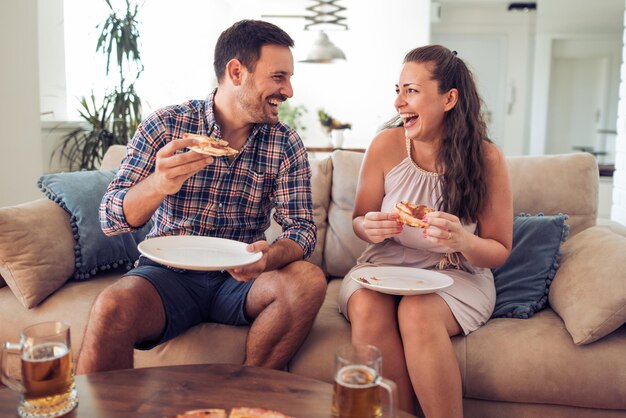 Gelukkig paar die pizza in bed eten