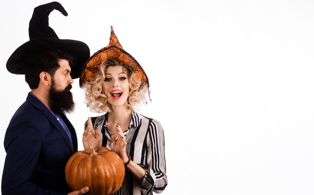 Gelukkig paar in heksenhoeden met pompoen. jongeren gekleed op halloween. feest en feest. 31 oktober.